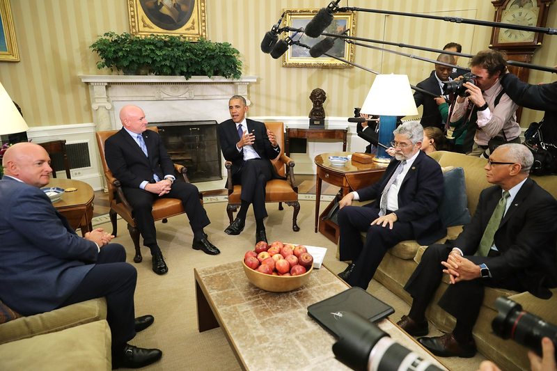 Here is the table holding a bowl of apples and two notebooks while it meets NASA astronaut Scott Kelly in October 2016. Image via Getty.